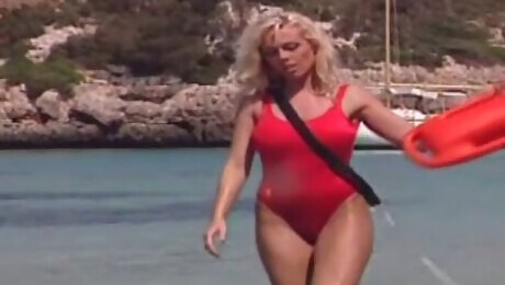 Saucy blond haired MILF in red swim suit performs steamy solo on sandy beach